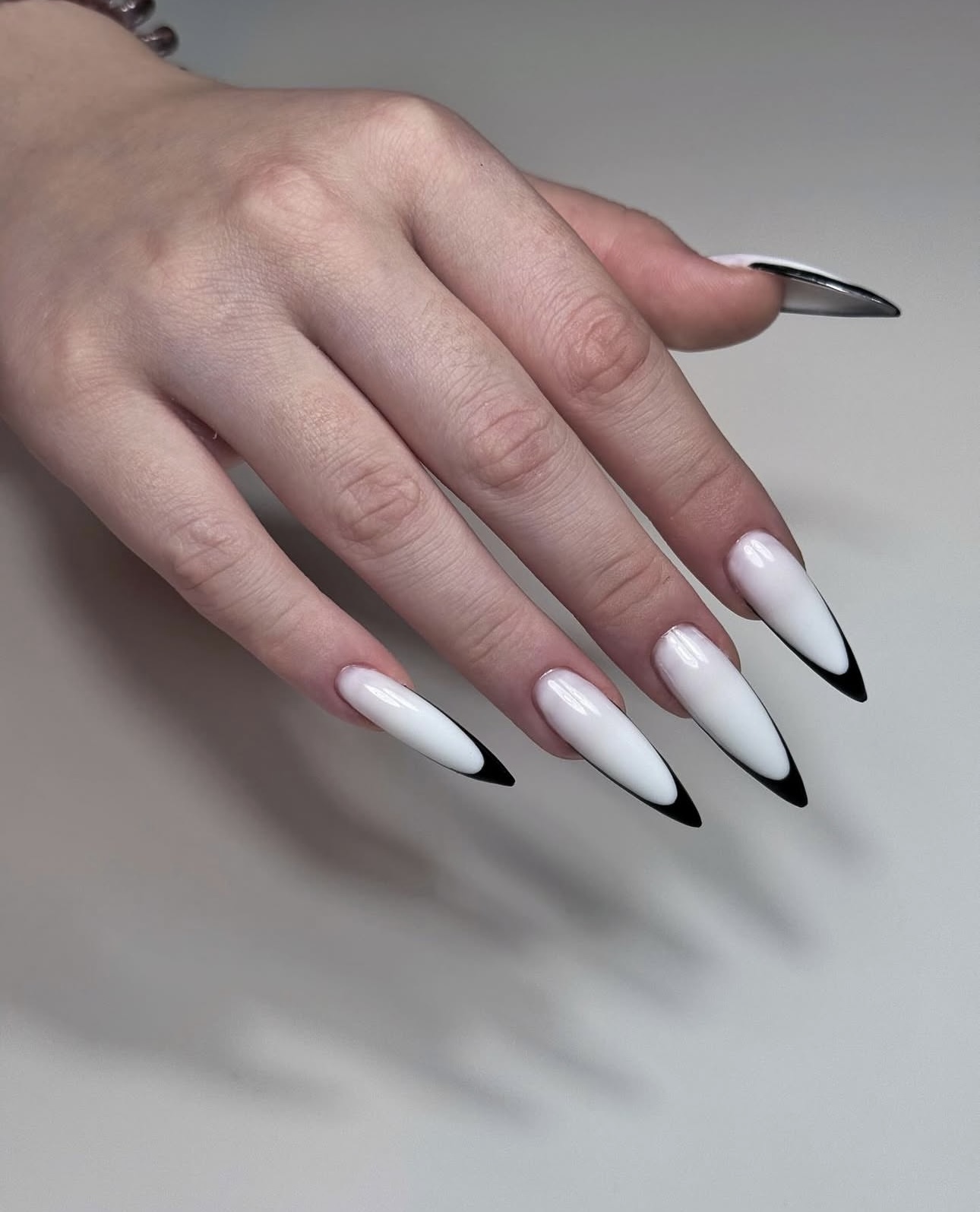 Lange stiletto-nagels met een witte French en zwarte randjes